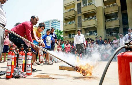 men with women tackles the fire using fire extinguisher